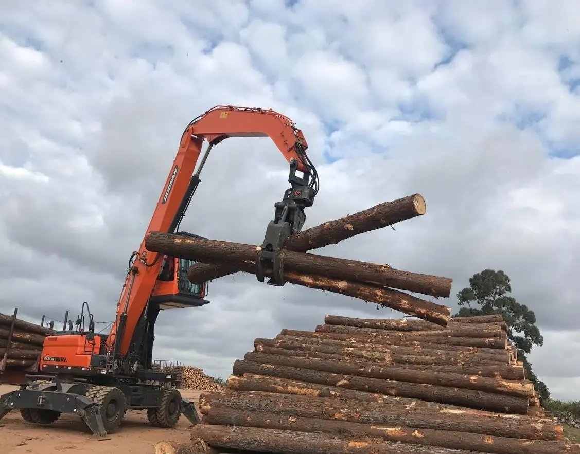 Manipuladora Doosan DX210W cargando troncos